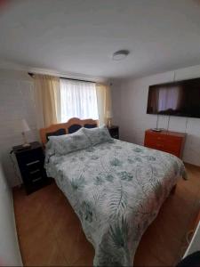 a bedroom with a bed with a comforter on it at CASA HABITACION PARA 6 PERSONAS in Coquimbo