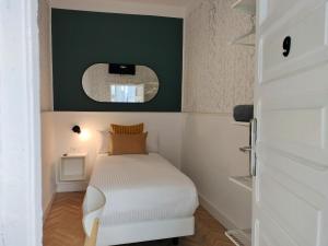 Dormitorio pequeño con cama y espejo en Room27, en La Laguna