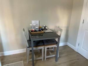 a desk with two chairs and a computer on it at Peacock Guest House in Largs