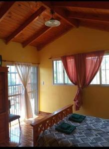 ein Schlafzimmer mit einem Bett und zwei Fenstern in der Unterkunft Casa en Balcón de Mallín, Mirador del Lago in Bialet Massé