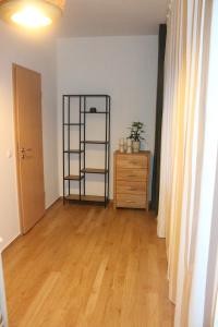 a room with a wooden floor and a shelf and a dresser at Ferienwohnung AM SPREEUFER in Hangelsberg
