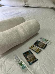a white bed with a towel and two batteries on it at Apartamento inteiro Varzea Grande MT in Várzea Grande
