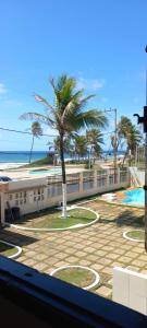 una vista della spiaggia e delle palme da una finestra di Casa di lana a Salvador