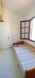 a bed in a room with a window at Casa di lana in Salvador