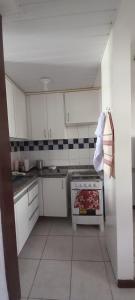 a small kitchen with white cabinets and a stove at Casa di lana in Salvador