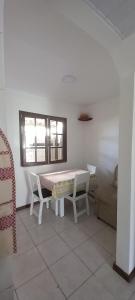 a white room with a table and chairs and a window at Casa di lana in Salvador