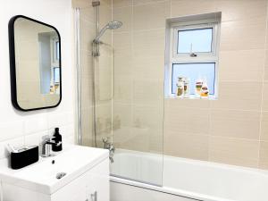a bathroom with a shower and a sink and a mirror at Luxury London Two Bedroom Apartment in West Dulwich