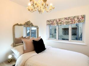 um quarto com uma cama com um espelho e janelas em Luxury London Two Bedroom Apartment em West Dulwich