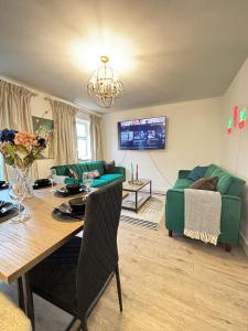a living room with a table and a green couch at Luxury London Two Bedroom Apartment in West Dulwich