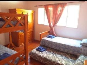 ein Schlafzimmer mit zwei Etagenbetten und einem Fenster in der Unterkunft Casa en Balcón de Mallín, Mirador del Lago in Bialet Massé