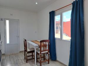 a dining room with a table and two chairs and a window at Las Grutas 5M in Las Grutas