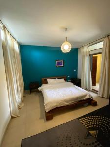 one bedroom apartments aqaba on 2 swimming pool Tala bay في العقبة: غرفة نوم بسرير مع جدار ازرق