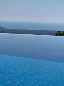 a swimming pool with blue water in the foreground at vista de loros in Sámara