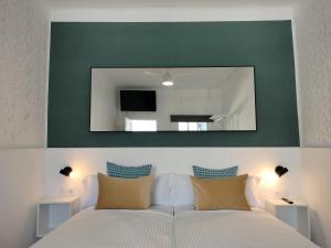 a bedroom with a large mirror above a bed at Room27 in Las Lagunas