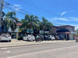 two people riding bikes down a street with parked cars at Punto Maschwitz Alquileres - Departamento dos ambientes in Ingeniero Maschwitz