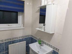 baño blanco con lavabo y ventana en Oasis Abode @Shiremoor, 