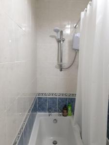 y baño blanco con bañera y ducha. en Oasis Abode @Shiremoor, 