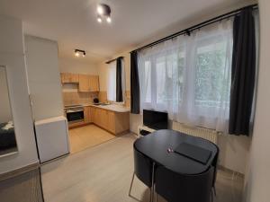 a kitchen with a table and a black stool in front of a window at HI Downtown Apartment A308 in Budapest