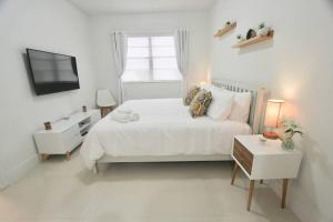 1 dormitorio blanco con 1 cama y TV en Modern 1 Bd Room 1 block from the Beach, en Miami Beach