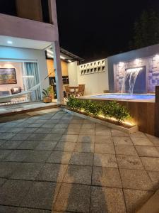Casa Sunstay Garden com piscina في بومبينهاس: ظل الشخص في الفناء في الليل