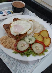 a plate of food with eggs and rice and vegetables at Jardim Paraíso in Duque de Caxias
