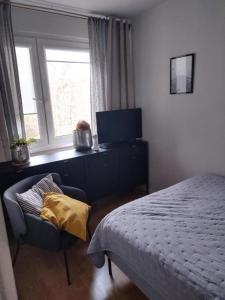 sypialnia z łóżkiem, krzesłem i oknem w obiekcie Mieszkanie 63 m w Kudowie Zdroju