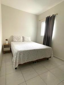 Schlafzimmer mit einem Bett und einem Fenster in der Unterkunft Apartamento Indicado no Centro Petrolina in Petrolina