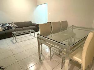 ein Wohnzimmer mit einem Glastisch und einem Sofa in der Unterkunft Apartamento Indicado no Centro Petrolina in Petrolina