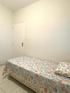 1 Schlafzimmer mit einem Bett mit Blumendecke in der Unterkunft Apartamento Indicado no Centro Petrolina in Petrolina
