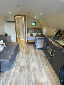 a living room with a couch and a kitchen at Morvan Pod & Hot tub in Fort William