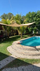 a backyard with a swimming pool and a umbrella at Beach Lomas in La Libertad