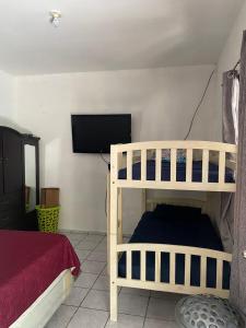 a bedroom with two bunk beds and a flat screen tv at Beach Lomas in La Libertad