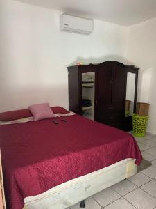 a bedroom with a red bed and a dresser at Beach Lomas in La Libertad