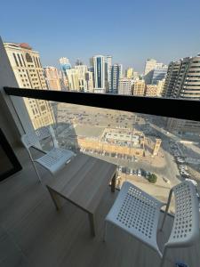 a balcony with two chairs and a table and a city at Sharja 904 in Sharjah