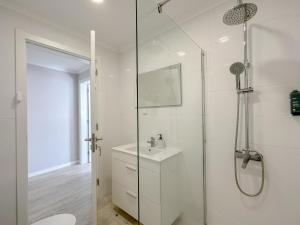 Un baño blanco con ducha y lavabo. en South Shore 1 - HOST & CHILL, en São Roque 24 fotos más