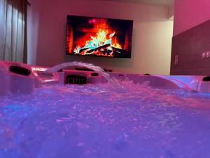 a bathroom with a hot tub with a fire in the tv at RheinMosel Glück Wellness in Koblenz