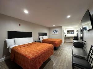 a hotel room with two beds and a bathroom at Palace Inn I-45 & Bellfort in Houston