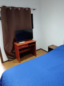 - une chambre avec un lit et une télévision sur une table dans l'établissement Condominio Doña Jacinta, à Valdivia