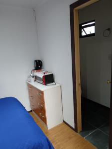 1 dormitorio con 1 cama y vestidor con tostadora en Condominio Doña Jacinta, en Valdivia