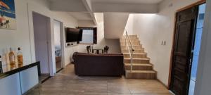 een woonkamer met een bank, een televisie en een trap bij CASA DE TAMANDARÉ in Tamandaré