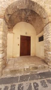 un ingresso a un edificio con porta in legno di Archi di San Giacomo a Cammarata