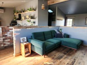 a living room with a green couch in a room at The Old Dairy on Winkleigh in Exeter