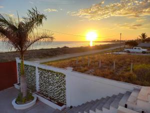 um pôr do sol na praia com uma palmeira em Puerto San Carlos Bay House & Tours -1st Floor- em San Carlos