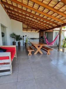 d'une terrasse avec une table en bois et un hamac. dans l'établissement Casa completa -prox Capitólio, Sto Hilário, Piment, à Pimenta