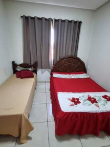 1 dormitorio con 2 camas con sábanas rojas y blancas en Casa completa -prox Capitólio, Sto Hilário, Piment, en Pimenta