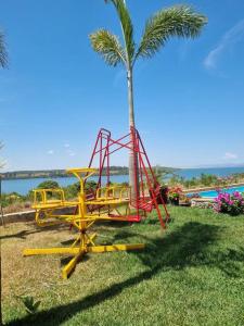 un parque infantil con una palmera y un columpio en Casa completa -prox Capitólio, Sto Hilário, Piment, en Pimenta
