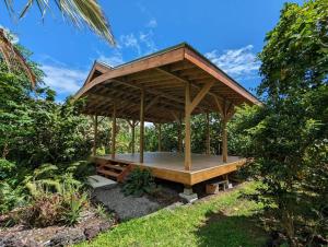 a wooden gazebo in the middle of a garden at Eco-Farm Glamping Mini House in Pahoa