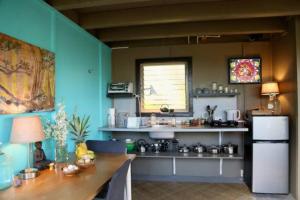een keuken met een tafel en een koelkast bij Eco-Farm Glamping Mini House in Pahoa