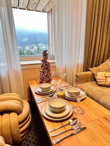a living room with a table with a christmas tree at ALPINA NEW apartment in the mountains in Špindlerův Mlýn