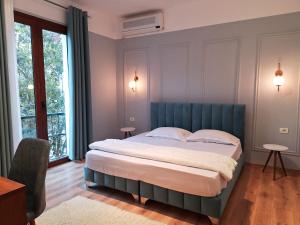 1 dormitorio con 1 cama grande y cabecero azul en Villa Mishel Suites, en Berat